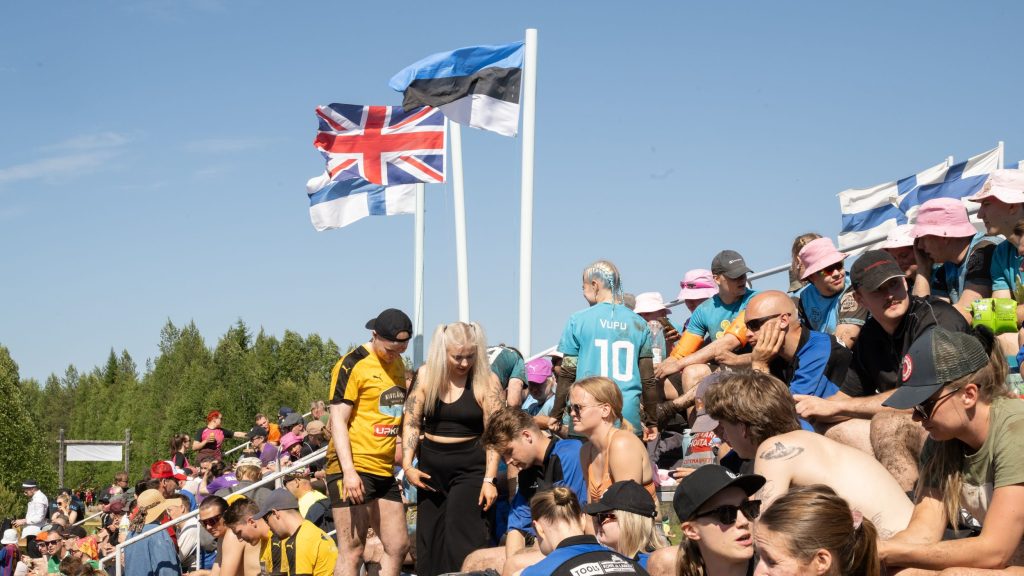 Kuvassa on katsomo, joka on täynnä ihmisiä. Taustalla liehuu Viron, Iso-Britannian ja Suomen liput