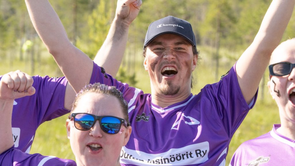 Joukkueen pelaajat tuulettavat ja huutavat kameraa katsoen. Kyseessä on Suopotkupallon MM-kilpailut vuonna 2025