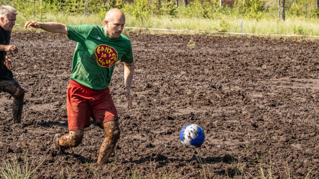 Kaksi miestä pelaa jalkapalloa suolla. Kyseessä on Suopotkupallon MM-kilpailut vuonna 2025