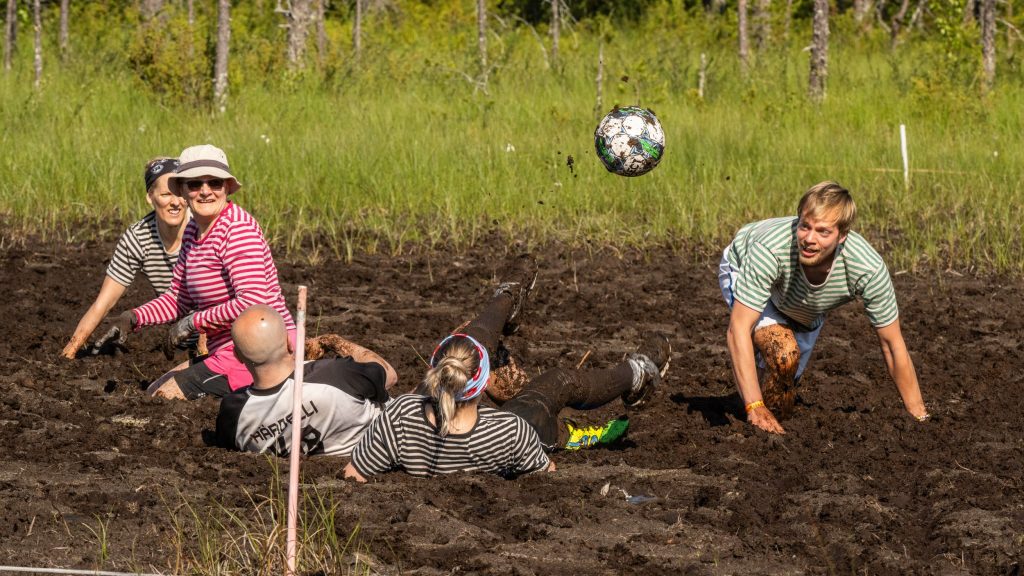 Miehistä ja naisista koostuvat joukkueet pelaavat jalkapalloa suolla. Kyseessä on Suopotkupallon MM-kilpailut vuonna 2025
