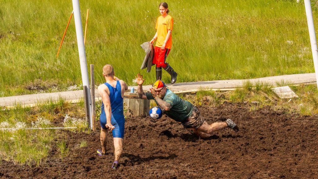 Kaksi miestä pelaavat jalkapalloa suolla. Kyseessä on Suopotkupallon MM-kisat 2025