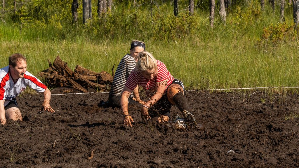 Miehistä ja naisista koostuvat joukkueet pelaavat jalkapalloa suolla. Kyseessä on Suopotkupallon MM-kilpailut vuonna 2025