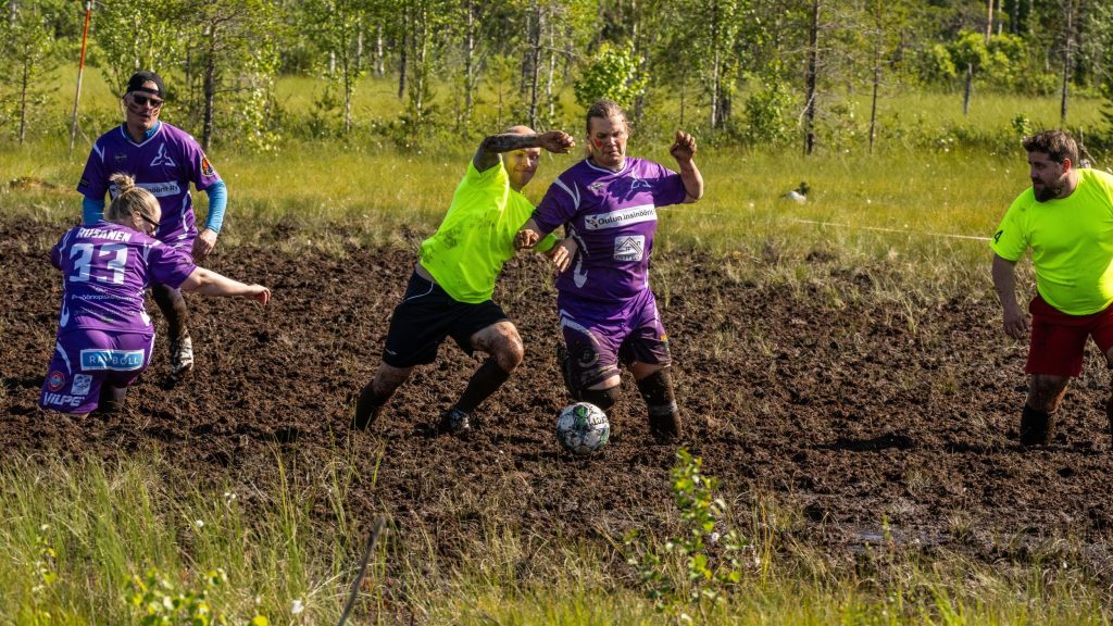 Miehistä ja naisista koostuvat joukkueet pelaavat jalkapalloa suolla. Kyseessä on Suopotkupallon MM-kilpailut vuonna 2025