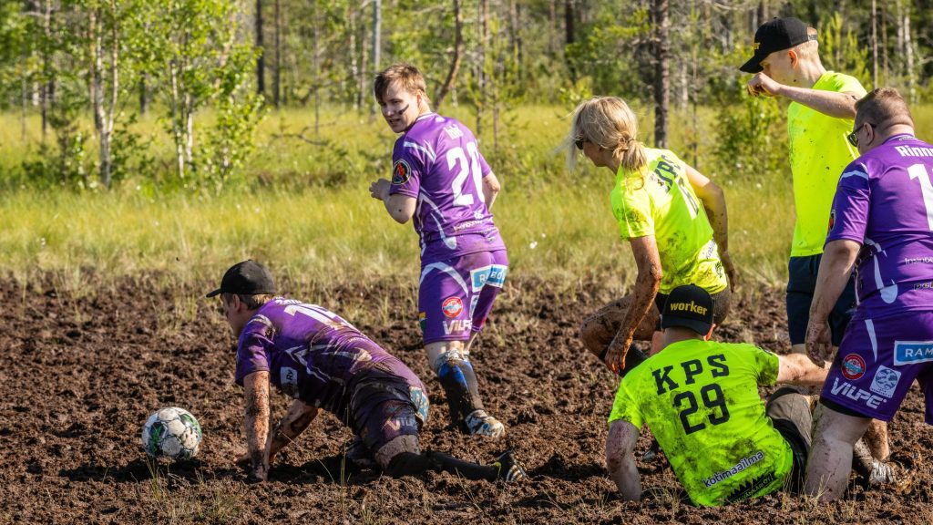 Miehistä ja naisista koostuvat joukkueet pelaavat jalkapalloa suolla. Kyseessä on Suopotkupallon MM-kilpailut vuonna 2025