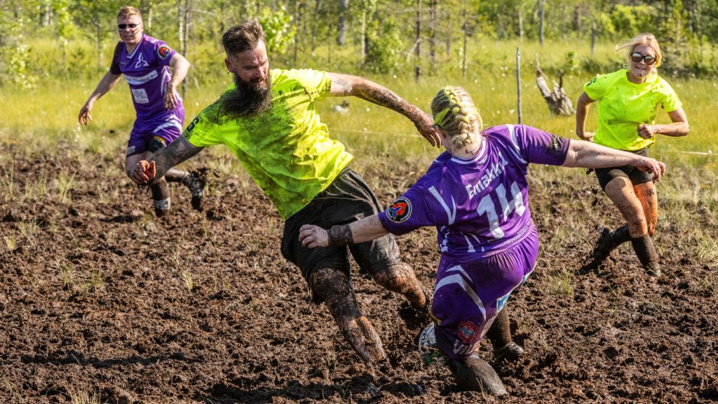 Miehistä ja naisista koostuvat joukkueet pelaavat jalkapalloa suolla. Kyseessä on Suopotkupallon MM-kilpailut vuonna 2025