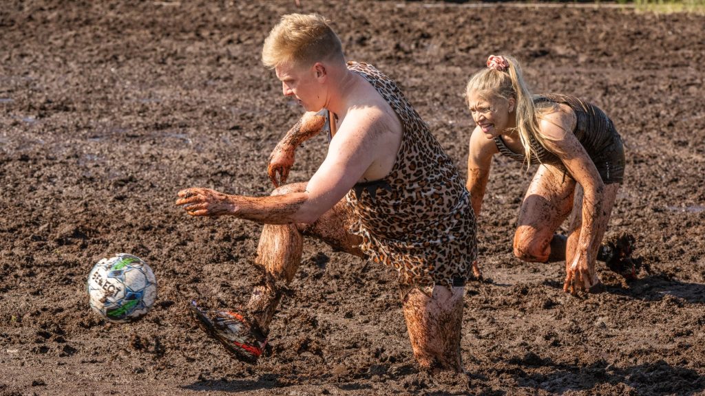 Miehistä ja naisista koostuvat joukkueet pelaavat jalkapalloa suolla. Kyseessä on Suopotkupallon MM-kilpailut vuonna 2025