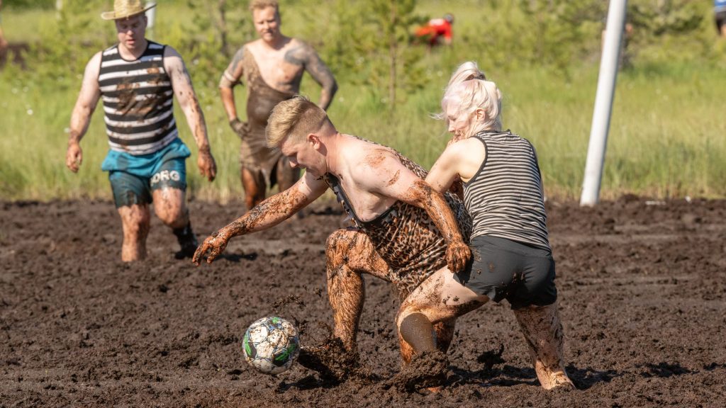 Miehistä ja naisista koostuvat joukkueet pelaavat jalkapalloa suolla. Kyseessä on Suopotkupallon MM-kilpailut vuonna 2025
