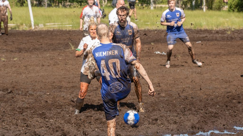 Miehistä ja naisista koostuvat joukkueet pelaavat jalkapalloa suolla. Kyseessä on Suopotkupallon MM-kilpailut vuonna 2025