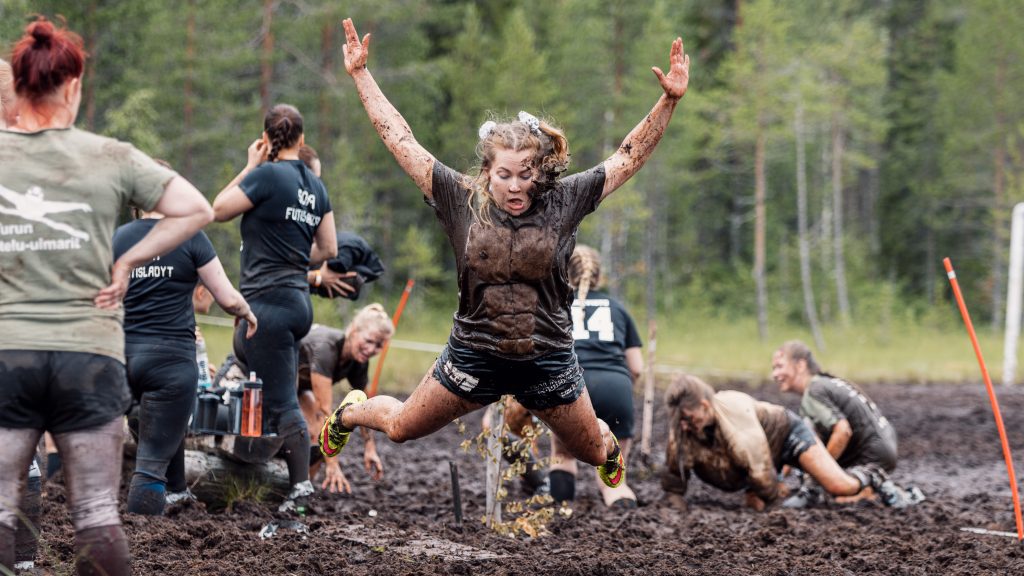 Nainen on hyppäämässä mahalleen suolle. Kyseessä on Suopotkupallon MM-kisat 2024